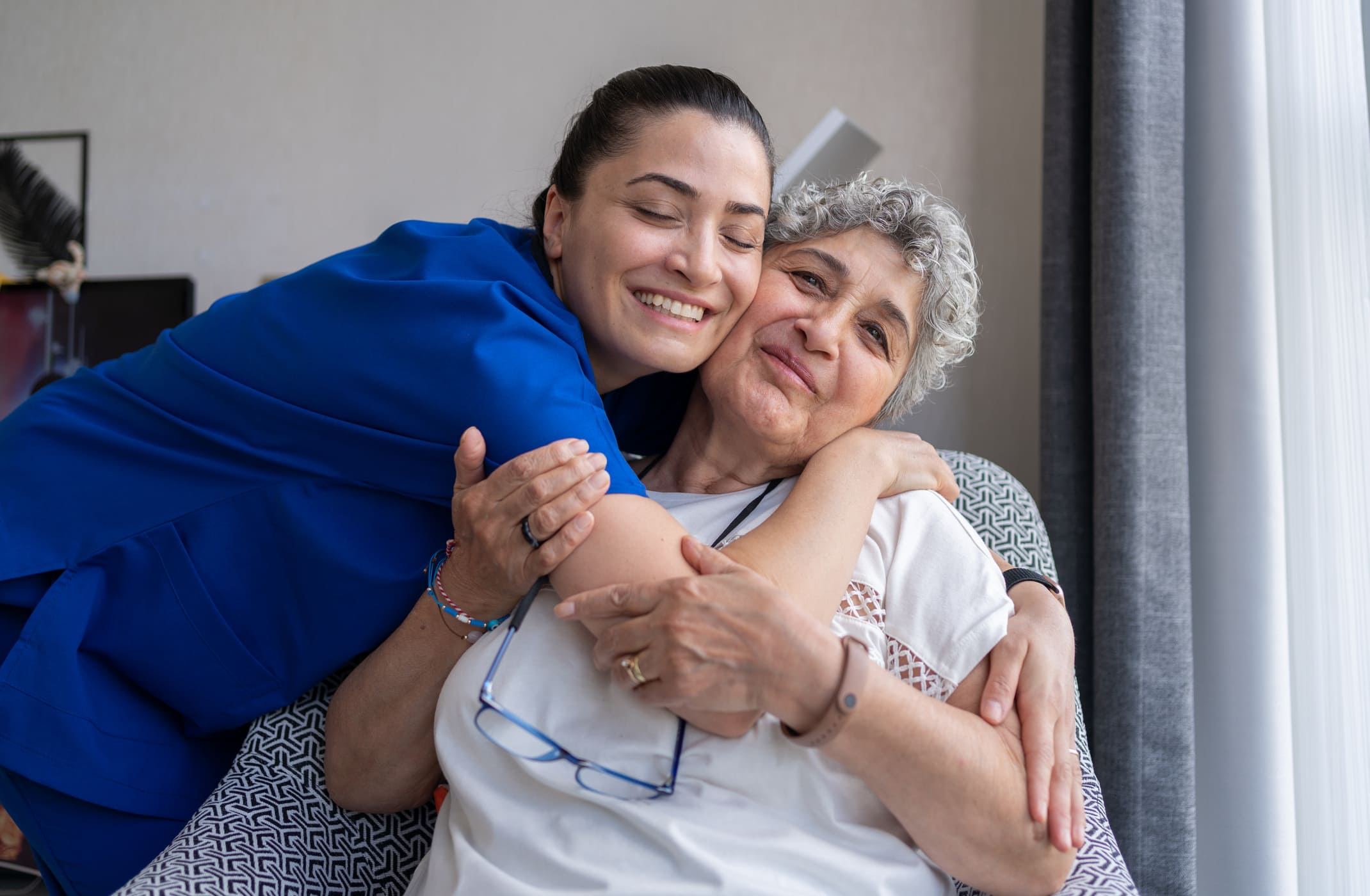 happy senior with loving staff member caregiver